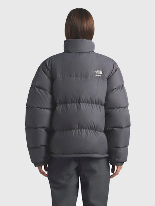 Recreated 1996 Nuptse grey parachute puffer jacket from The North Face × SKIMS featuring warm padding and sleek winter styling.