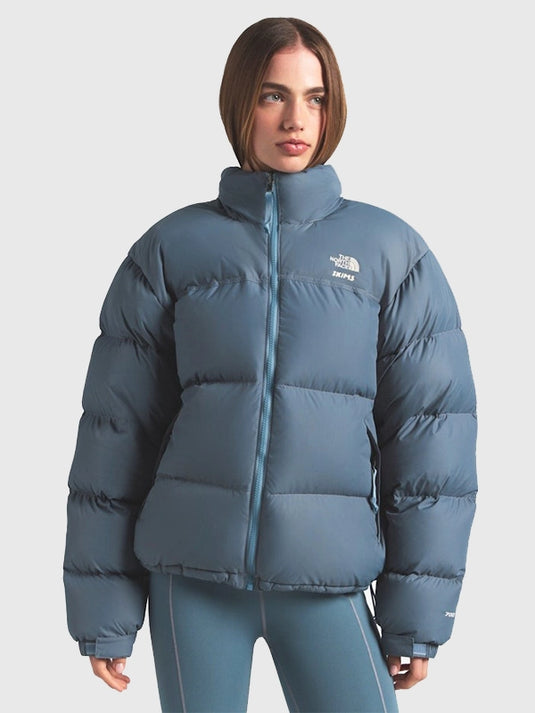 The North Face × SKIMS blue Nuptse parachute puffer jacket recreated with soft padded layers and streamlined fit.