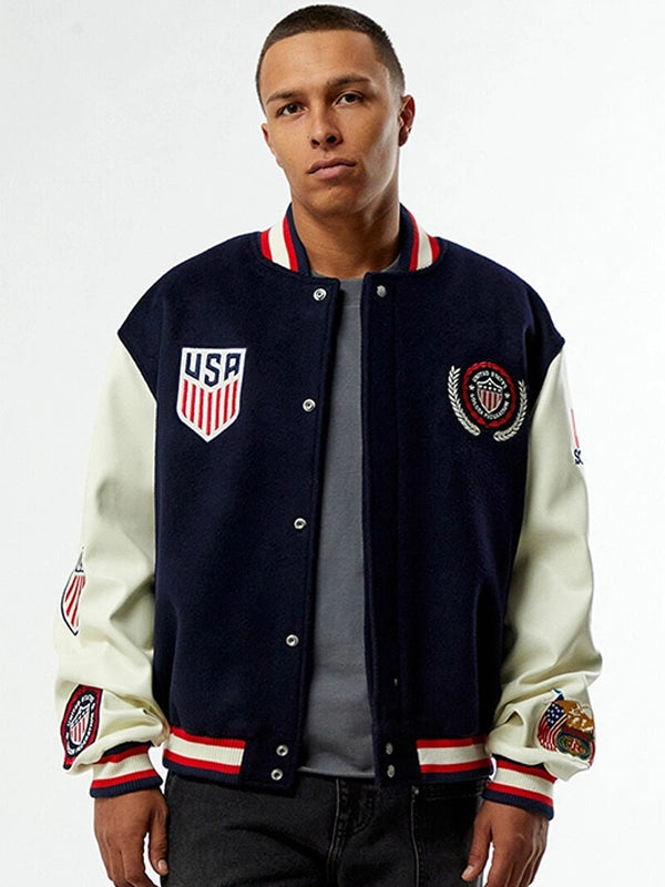 Man wearing a navy and white varsity jacket with USA emblem on a white background