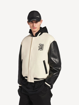 Cream wool varsity jacket with black leather sleeves from NBA x Balenciaga 2026 featuring oversized luxury streetwear attitude