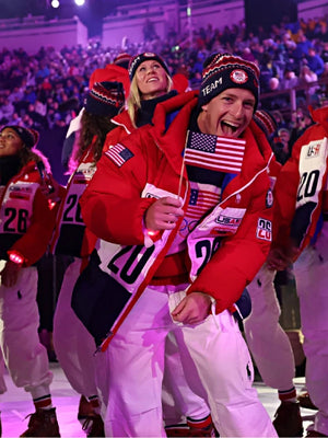 Red and white Team USA hooded puffer jacket inspired by the Milano Cortina 2026 Winter Olympics closing ceremony with insulated quilted construction