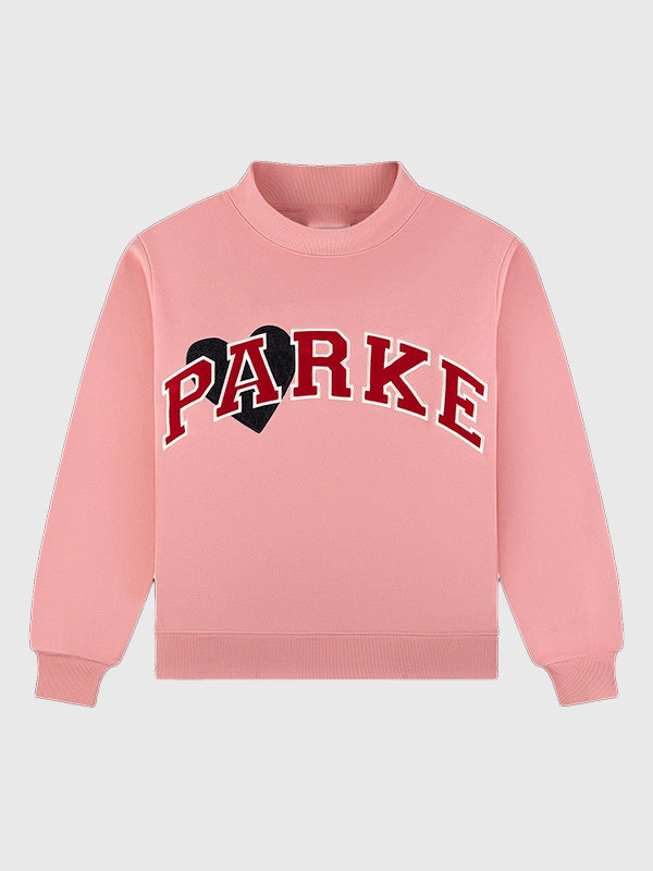 Pink RECREATED Women’s Parke Valentine’s 2026 Jean Heart mockneck sweatshirt featuring varsity-inspired styling
