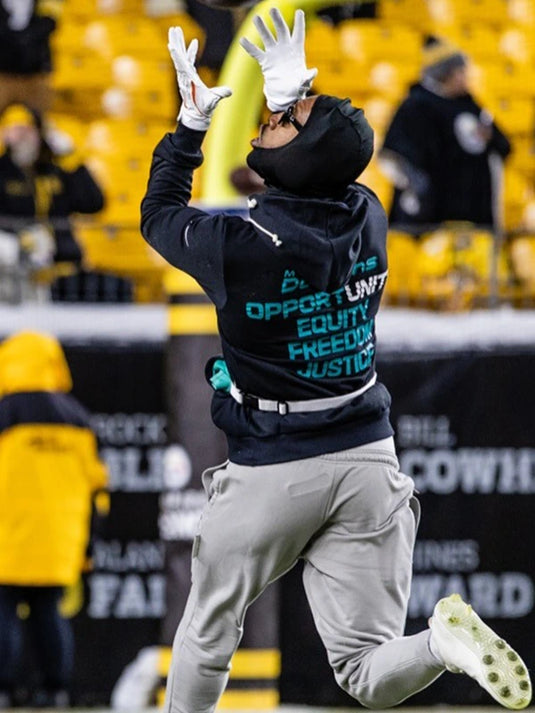 Black Miami Dolphins 2025 Nike sideline pullover hoodie highlighting the Inspire Change theme and statement wording