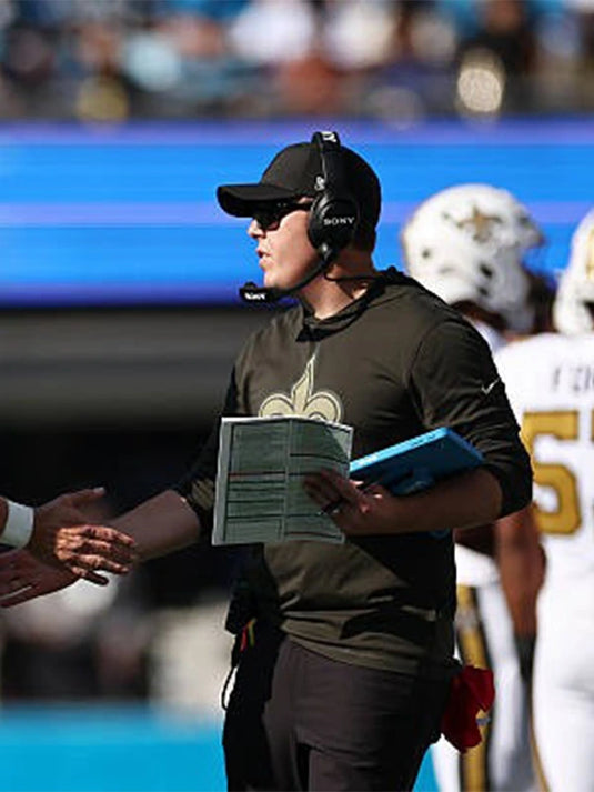 New Orleans Saints 2025 forest green Salute to Service pullover hoodie T-shirt featuring coach-inspired details.

