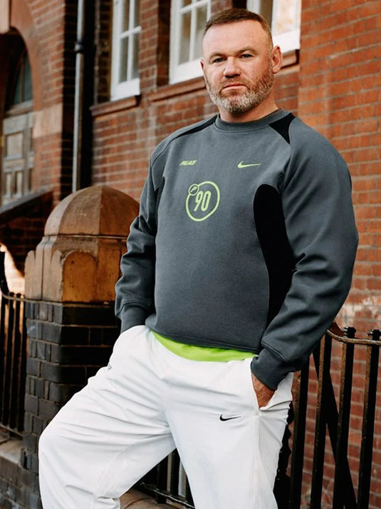 Palace x Nike P90 crew sweatshirt in charcoal grey fleece, merging sportswear aesthetics with street attitude.