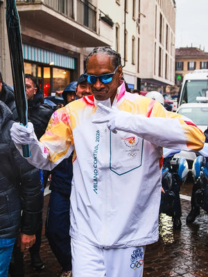 White full-zip jacket recreated from the Milano Cortina 2026 Winter Olympics collection, inspired by Snoop Dogg as torchbearer, featuring lightweight insulation.