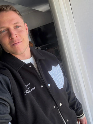 Black wool varsity jacket recreated with leather sleeves, drawing inspiration from Christian McCaffrey’s 2026 Pro Bowl Games outerwear style.