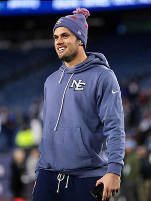 Patriots 2025 Rivalries pullover hoodie in storm blue modeled after Drake Maye’s sideline gear.