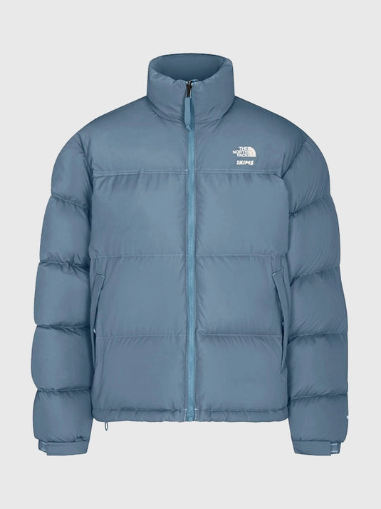 Blue Nuptse puffer jacket recreated from The North Face × SKIMS 2025 drop with boxy silhouette and lightweight parachute shell.